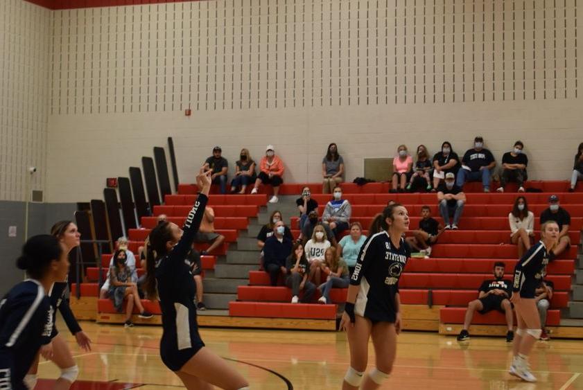 Volleyball players on court during a home match. 